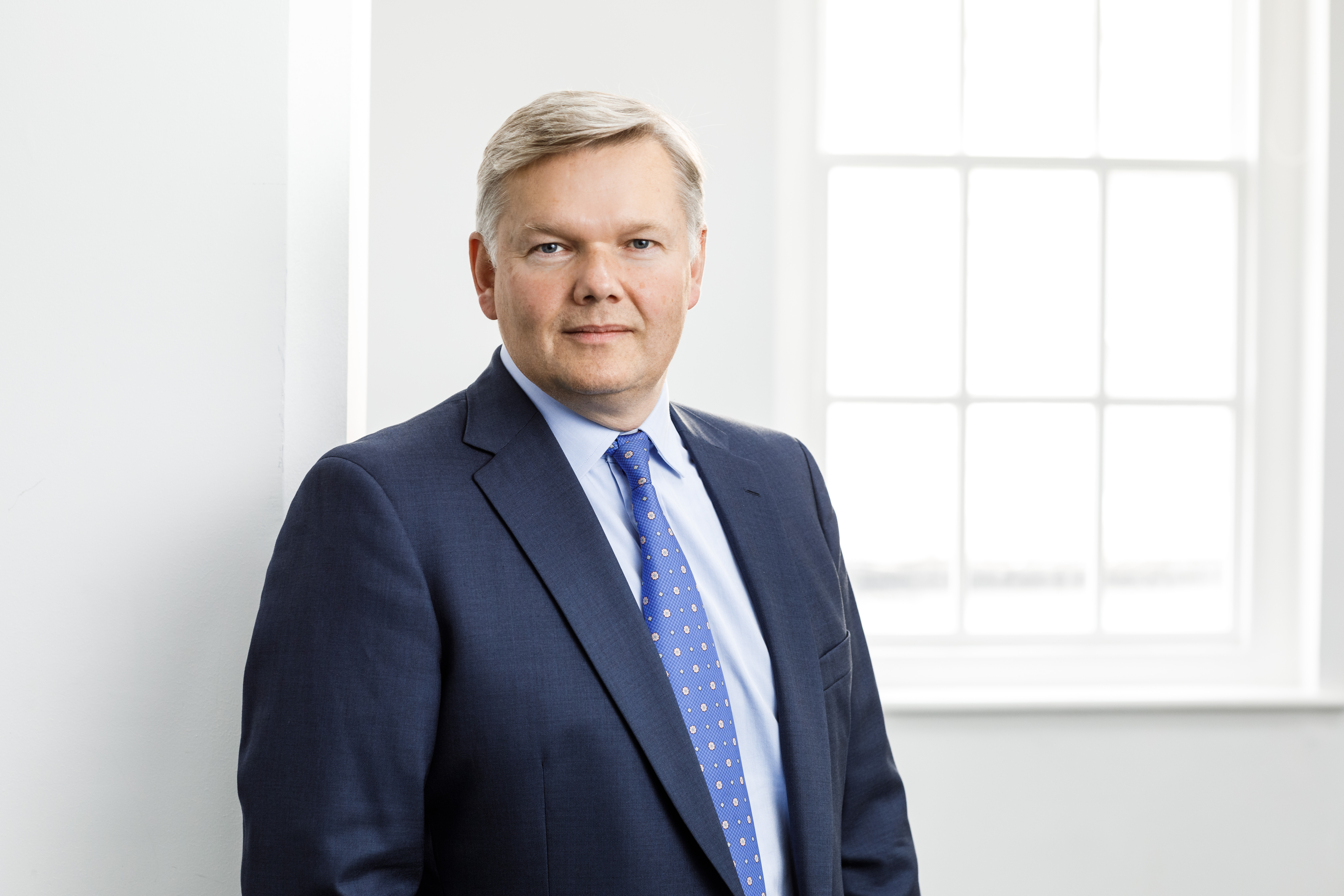 Head of Pensions, Peter Culnane, wearing a suit and blue tie